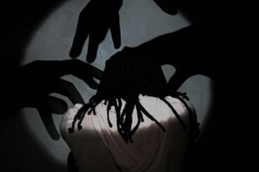 mujer siendo rodeada por sombras de manos